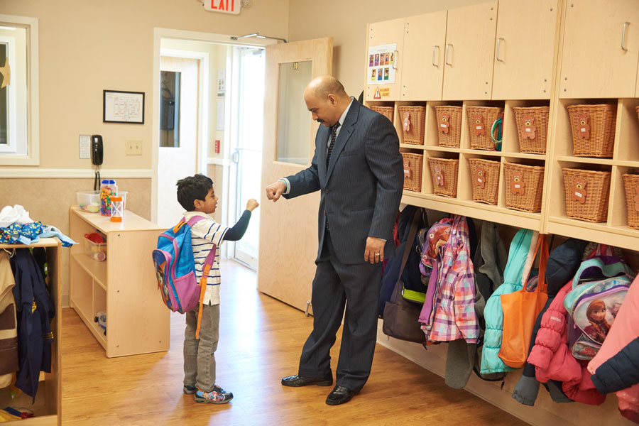 A teacher fist bumping a Pre-K student