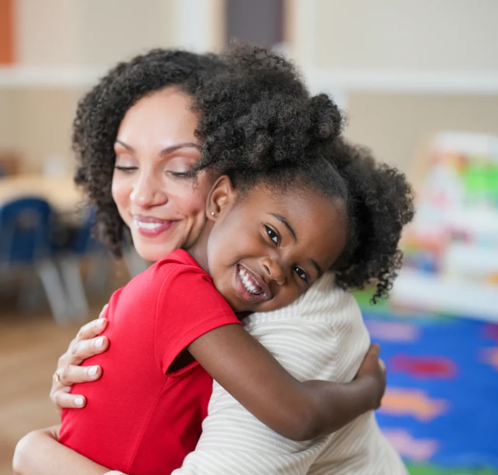 A mother hugs her smiling daughter at a Lightbridge Academy center