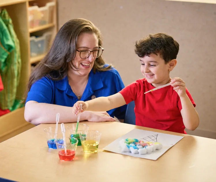 A teacher and child doing an art project together.