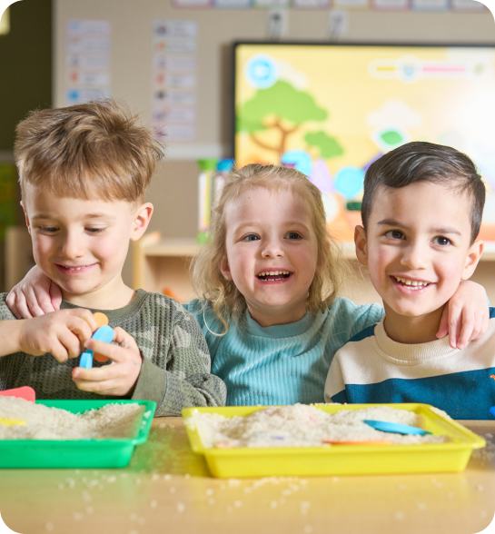 A teacher and two children in a classroom.