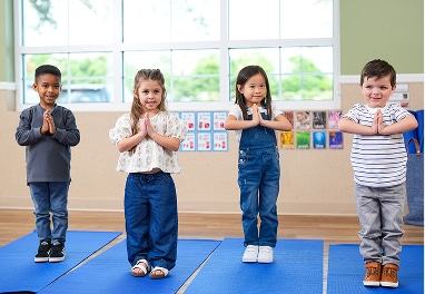 Four children in a yoga pose.