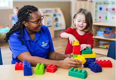 A teacher and child playing with blocks.