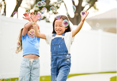Children playing with bubbles outside.