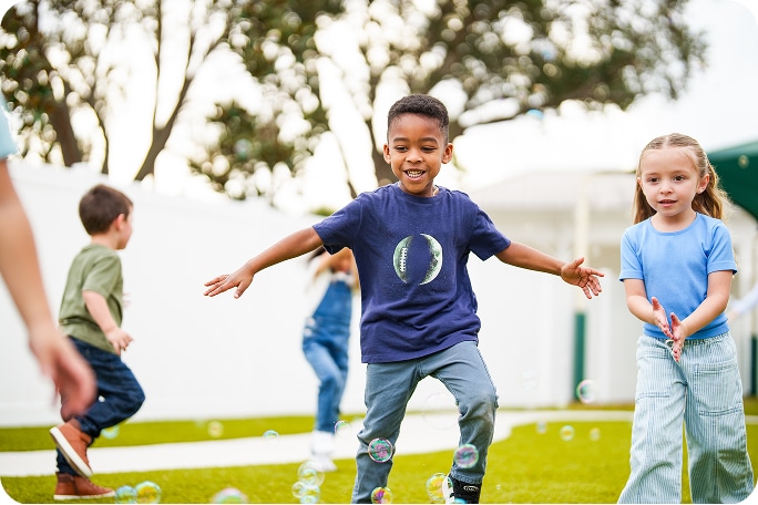 Children playing with bubbles outside.