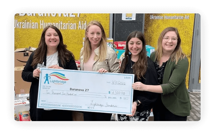Four women holding a large check.