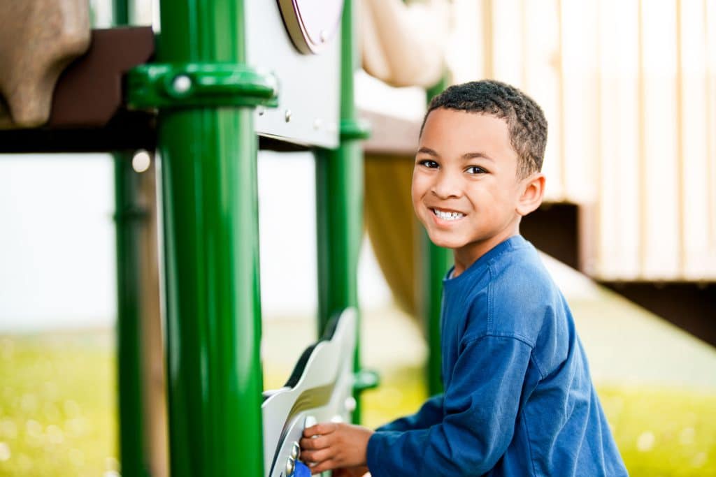A smiling boy on a playground.