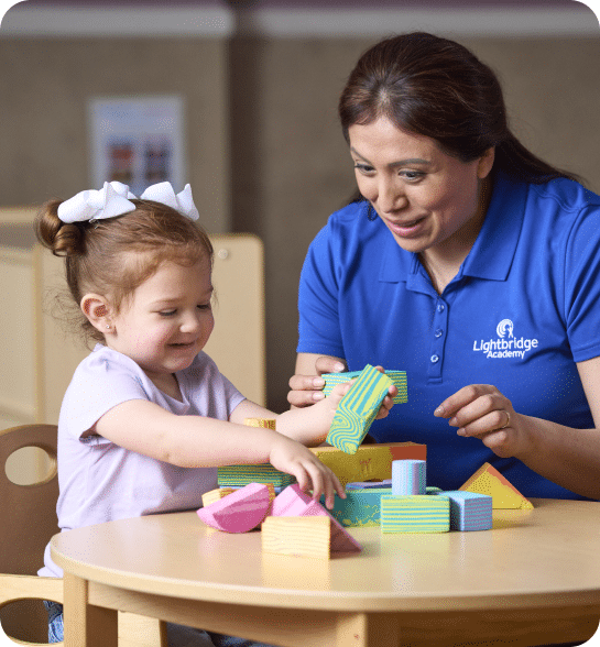 A teacher and child playing with blocks.