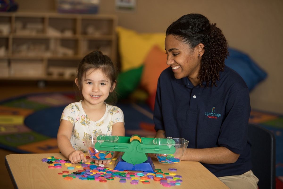 A preschool teacher playing a game with a child