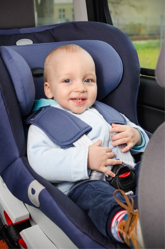 Young child safely secured in a car seat for a family road trip