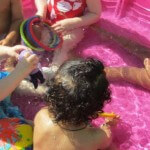 Young children playing in a kiddie pool