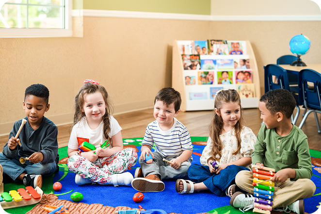 Five children sitting in a circle playing musical instruments.