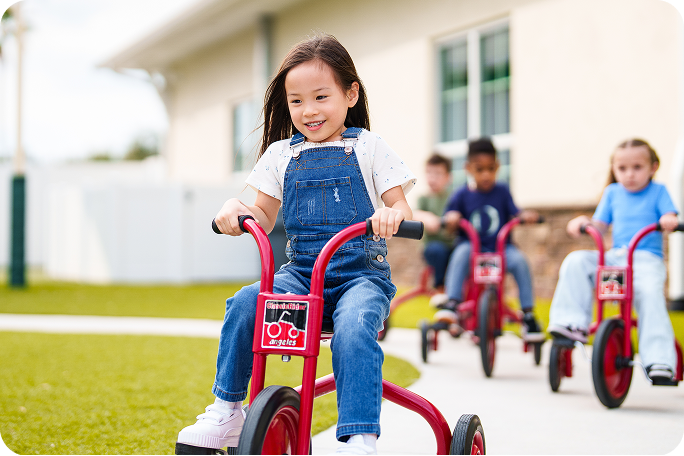 Children riding tricycles on a playground.
