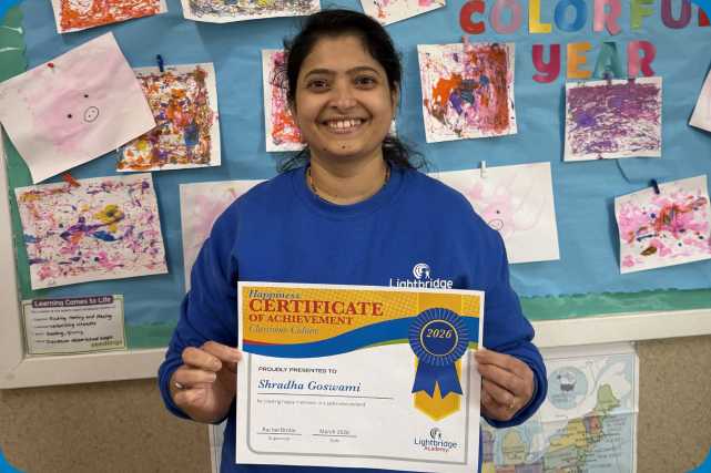 A teacher holding an award certificate.